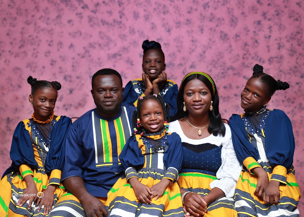 Portrait of a smiling African family in vibrant traditional attire, celebrating culture and togetherness.